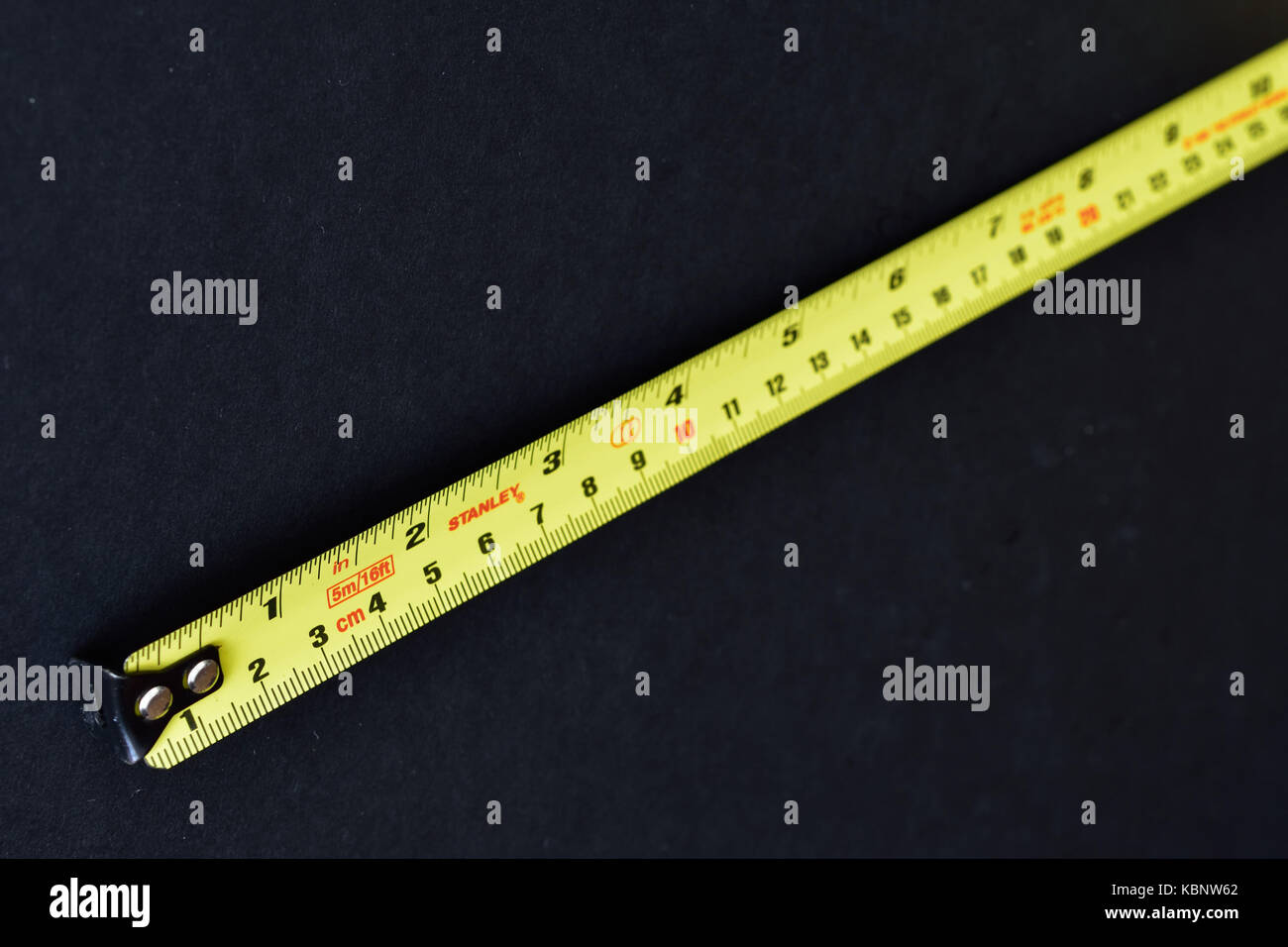 https://c8.alamy.com/comp/KBNW62/yellow-stanley-steel-tape-measure-on-black-background-KBNW62.jpg