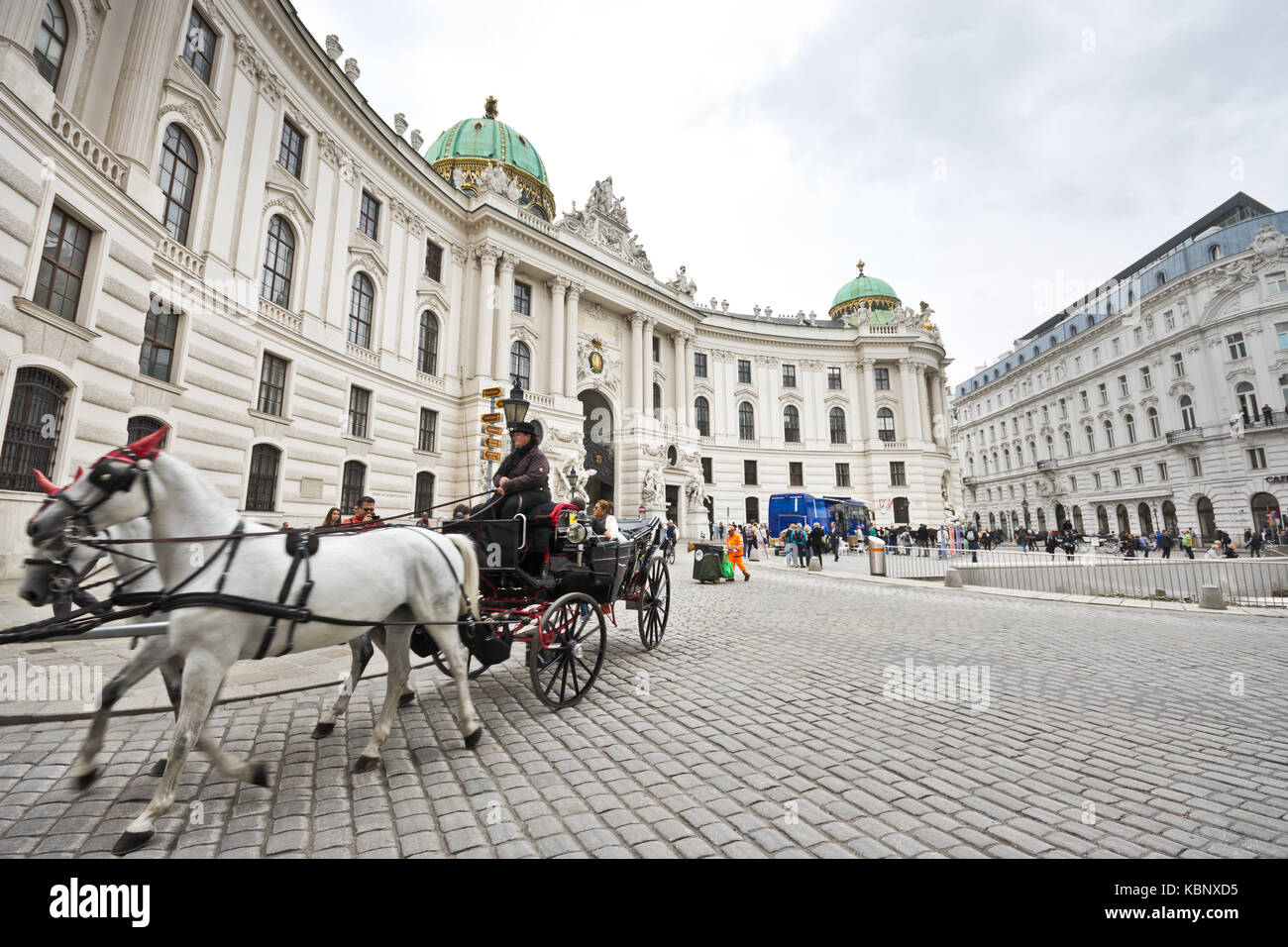 Famous horse-drawn carriage called fiaker passes by the Hofburg palace ...