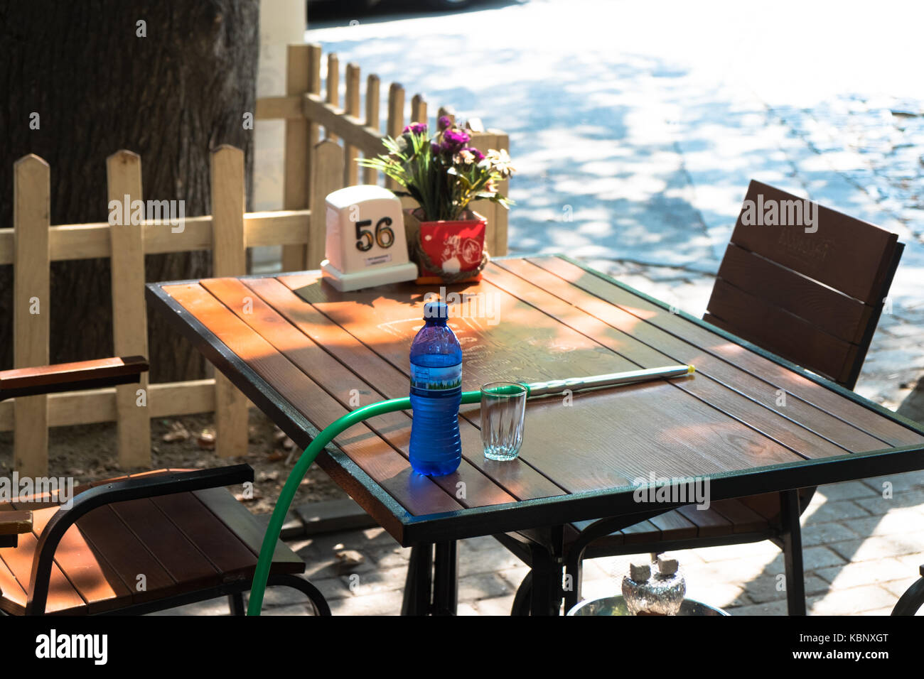 cafe table with a glass and mineral water on it in color in the city Stock Photo