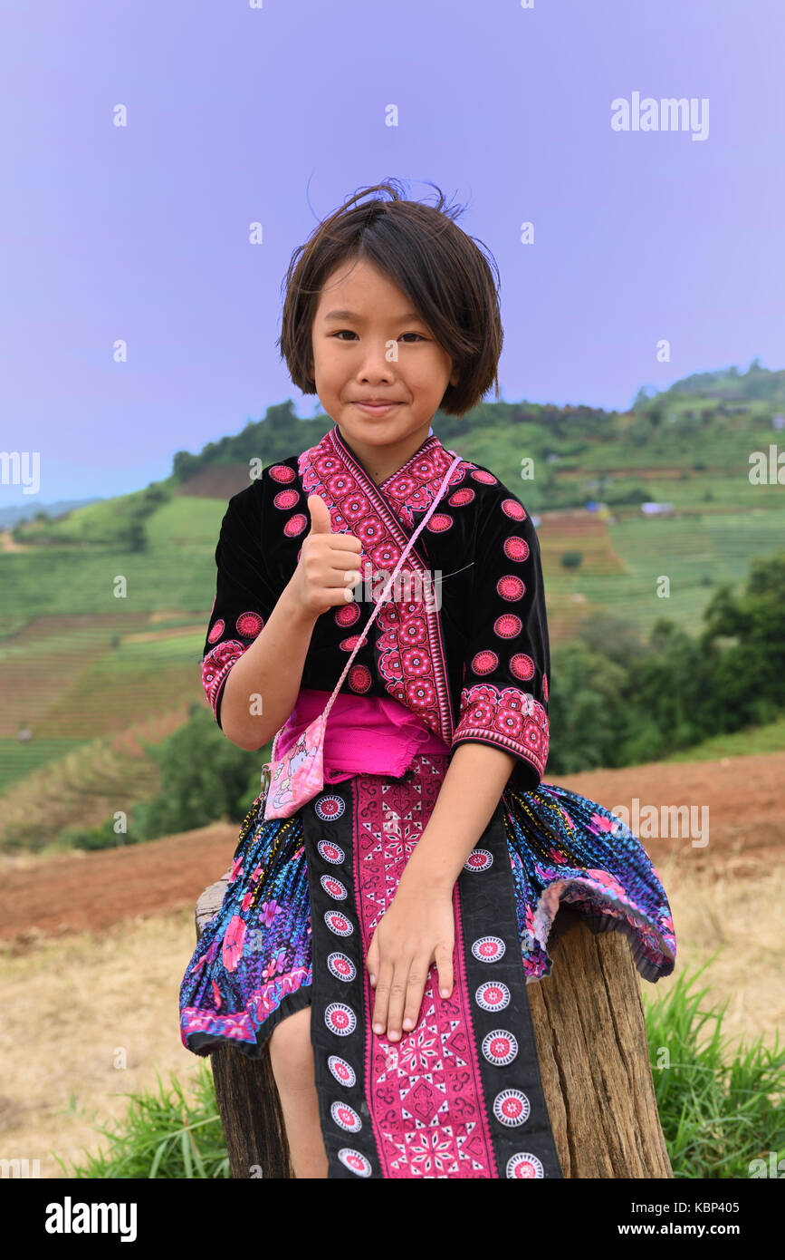 Young Hmong girl wearing traditional dress poses for the camera at the mountain viewpoint of Mon Cham, Chiang Mai Province, Thailand Stock Photo