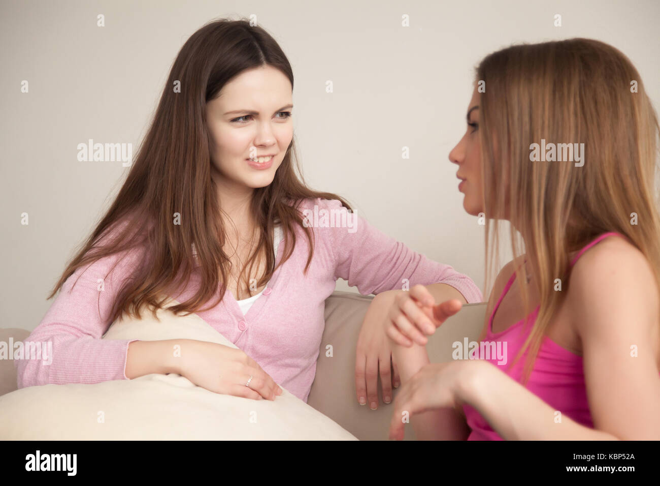 Two young girlfriends having personal conversation. Stock Photo