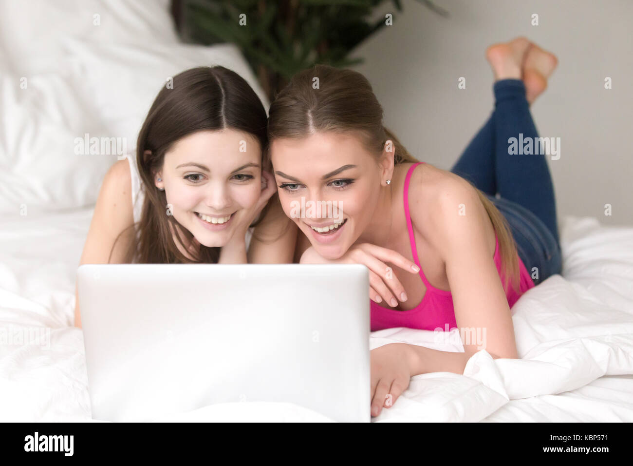 Two girlfriends looking at laptop screen with expression of exci Stock Photo