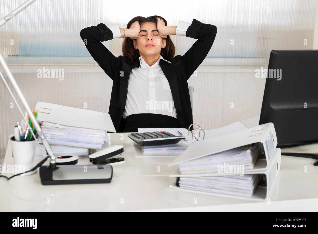 Tensed female accountant sitting with head in hands at desk in office Stock  Photo - Alamy