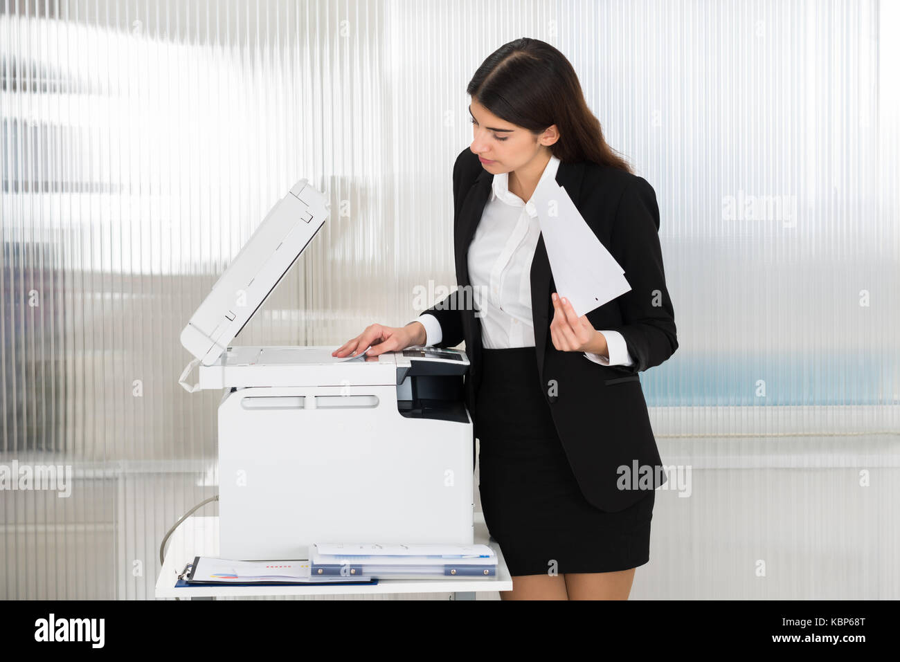 Young businesswoman using photocopy machine in office Stock Photo
