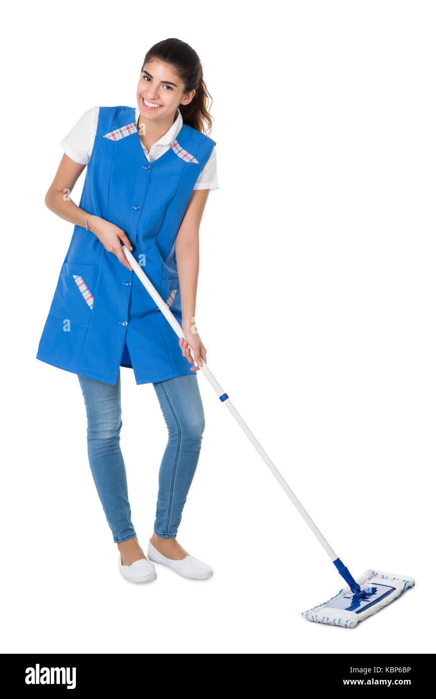 Full length portrait of happy female janitor mopping on white background Stock Photo