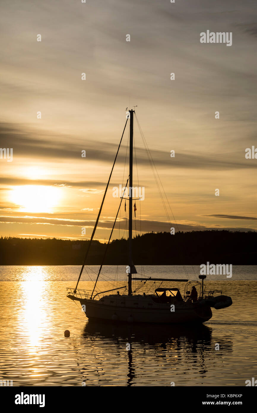 Sailboat leaving harbour early in the morning. Stock Photo