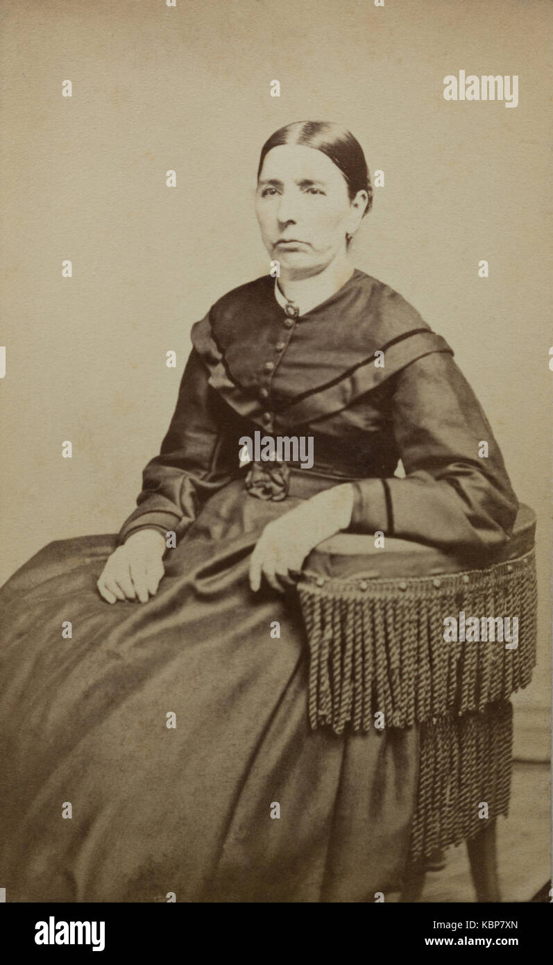 American archive monochrome studio portrait photograph of older woman with stern expression sitting on a chair and wearing a dark dress, named as Matilda Gage, taken in late 19th century by Gilmore's Gallery of Art, Binghamton, NY, USA Stock Photo