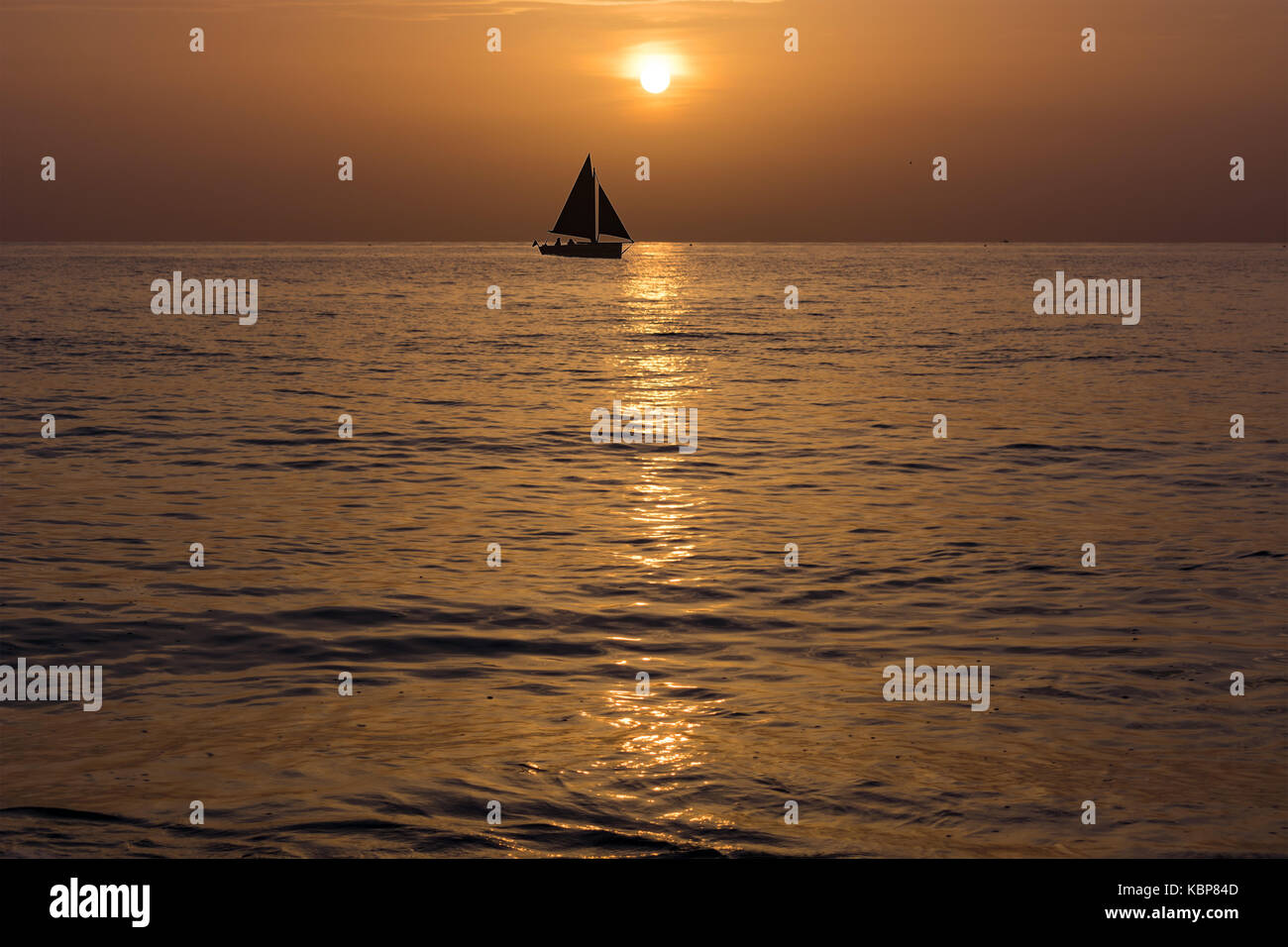 sail boat silhouette on the horizon just after sunrise Stock Photo - Alamy