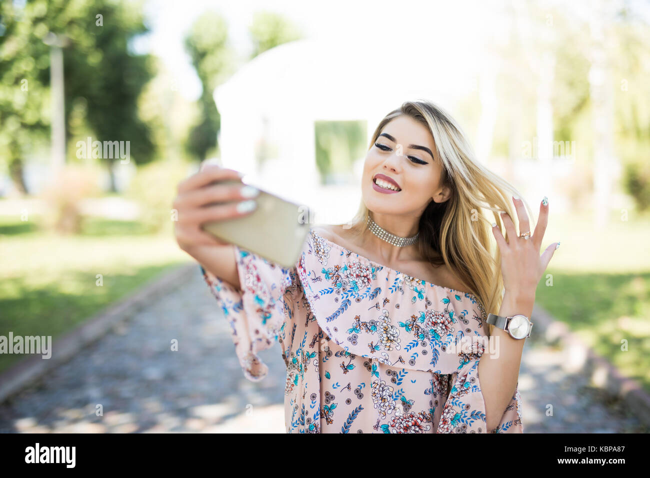 POrtrait of a smiling young girl making selfie photo in park Stock ...
