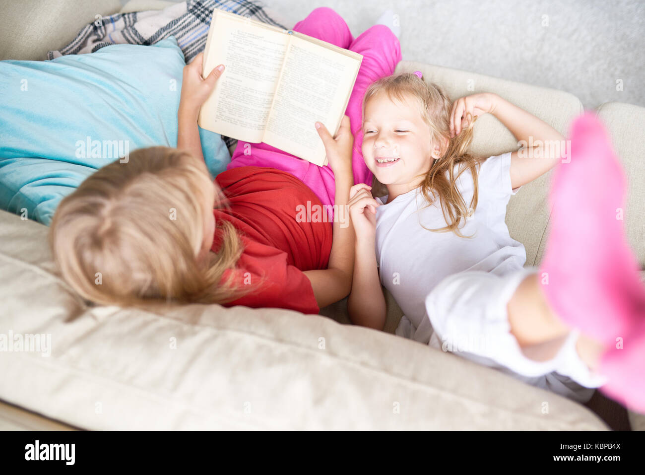 лежу младшей сестре. брат лежит на сестре. сестра лежала. маленькая сестренка на диване. ребёнок лежит на сестре.