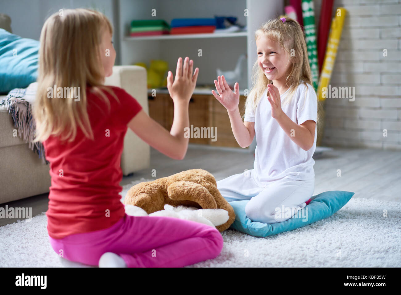 Сестренка отдыхает. Девочка играет на полу. Две девочки играют на полу. Две девочки сидят на полу. Девочка играет с сестрой.