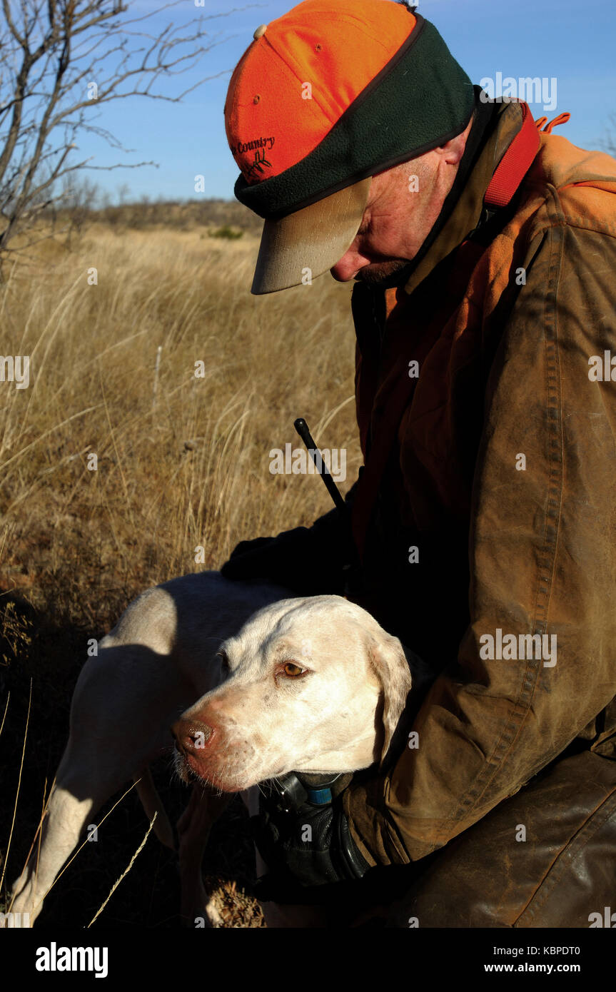A quail hunter embracing his English Pointer hunting dog in West Texas Stock Photo