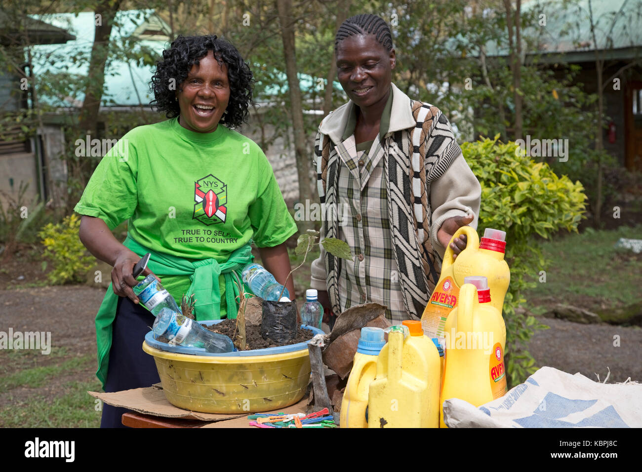 African women using plastic water bottles to irrigate young seedings Elsamere Kenya Stock Photo