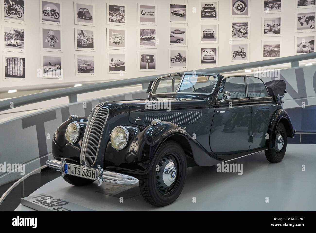 a black vintage car in front of a picture wall in BMW Museum, Munich, which is a famous germany auto brand Stock Photo