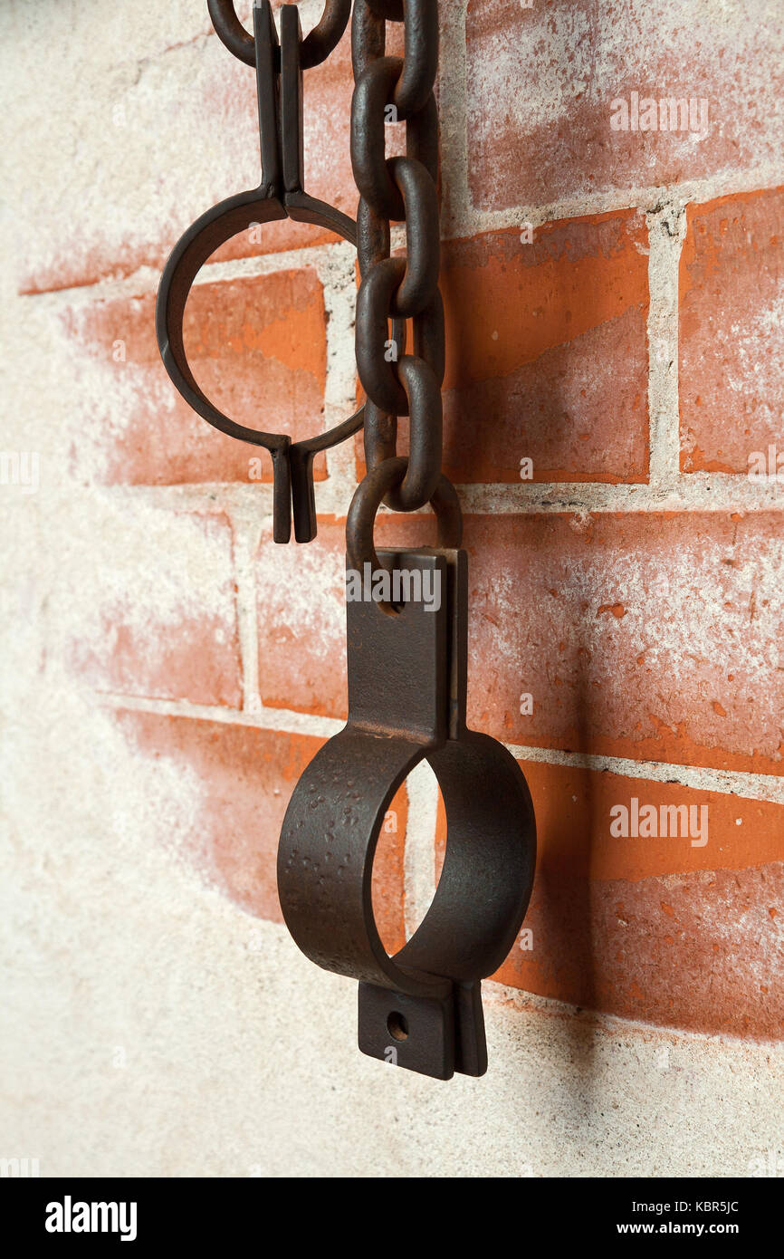 Old rusty shackles on a brick wall Stock Photo