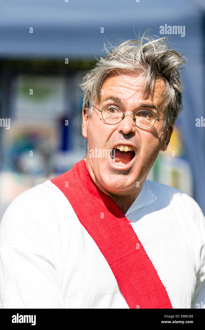 England, Sandwich. Living history re-enactment. Medieval man with glasses, shouting loudly, mouth wide open. Head and shoulders. Stock Photo