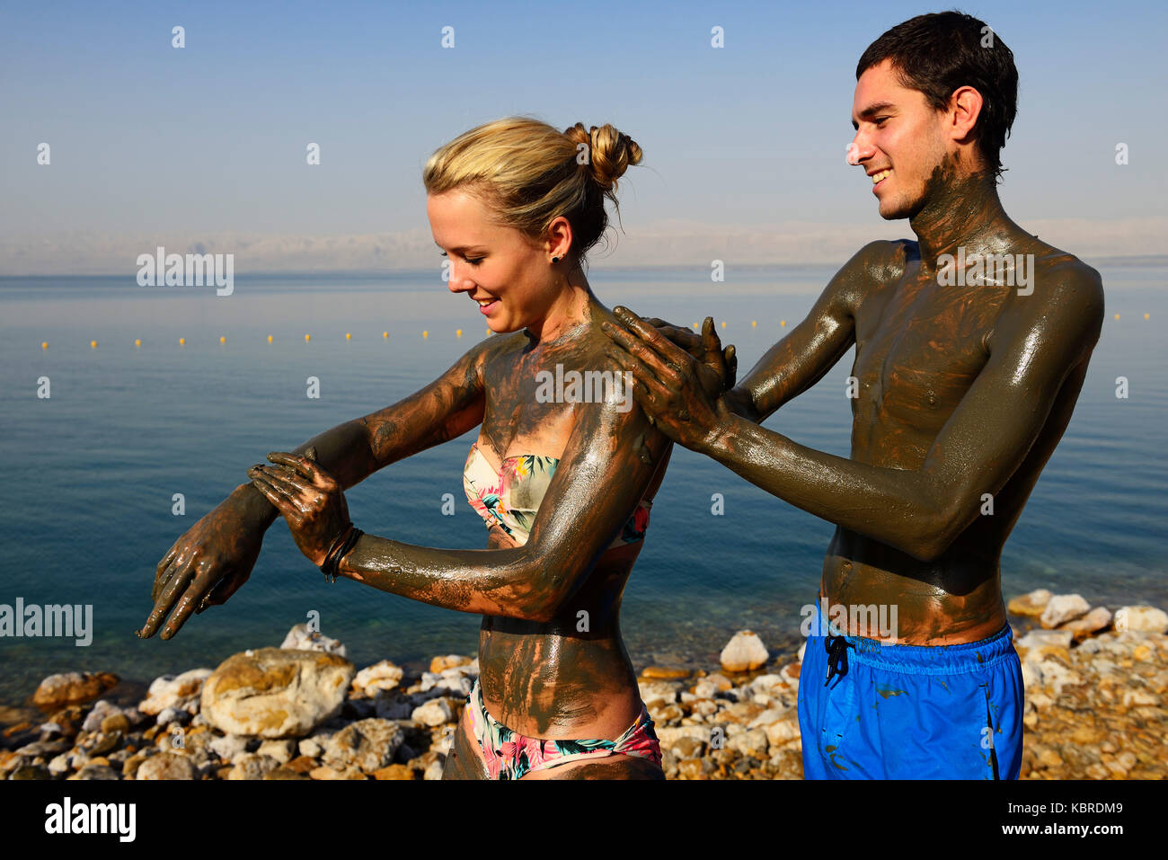 Young Couple uses Clay of Dead Sea for cleaning skin, Jordan Stock Photo