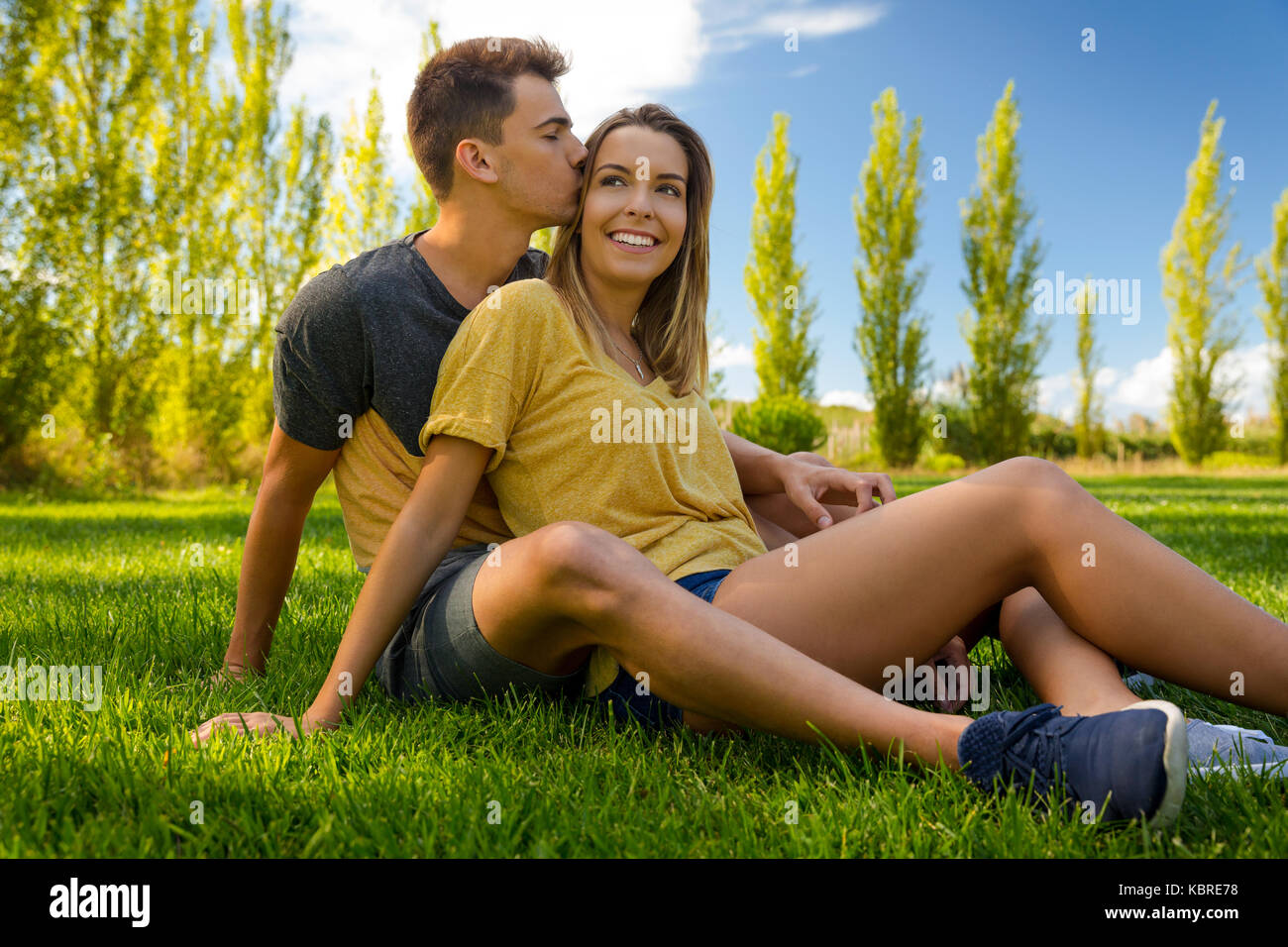 Young couple sitting on the grass and relaxing Stock Photo - Alamy