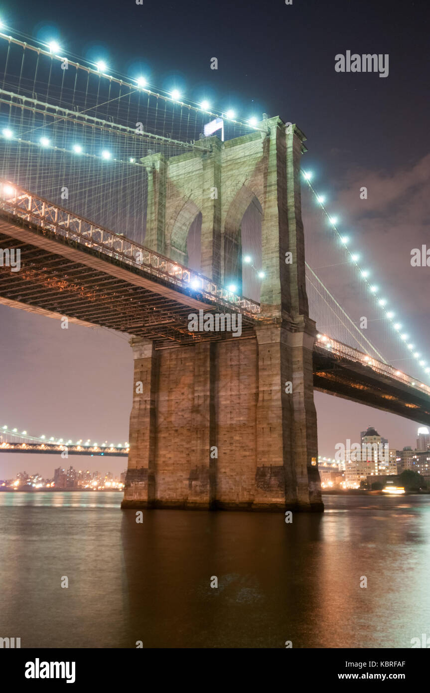 Brooklyn Bridge closeup over East River at night in New York City ...