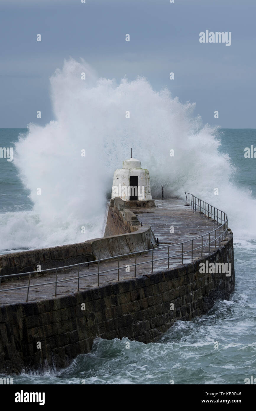Breaking wave against a sea wall - Portreath, Cornwall Stock Photo