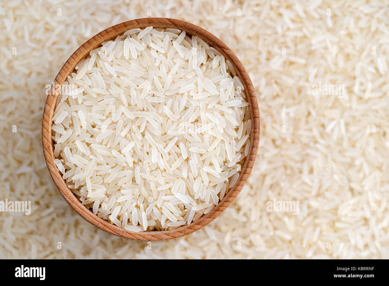 Healthy food. Wooden bowl filled long parboiled rice on blurred background. Close up, top view, high resolution product. Stock Photo