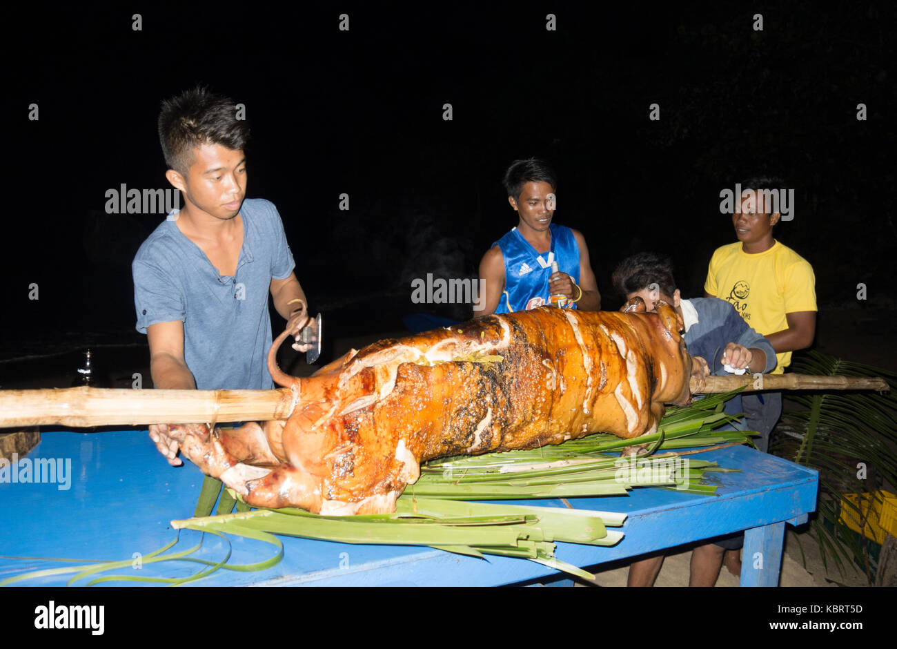 Philippines food preparation - holiday staff preparing a hog roast barbecue on the beach, El Nido, Palawan, Philippines Asia Stock Photo