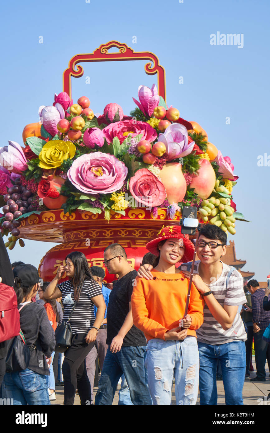 Tiananmen Square, Beijing, China. 1st October, 2017. a young couple taking photos in front of the big flower basket installation on Tiananmen Square, Beijing, China, on the China National Day of 2017, October 1st Credit: Yi Liao/Alamy Live News Stock Photo