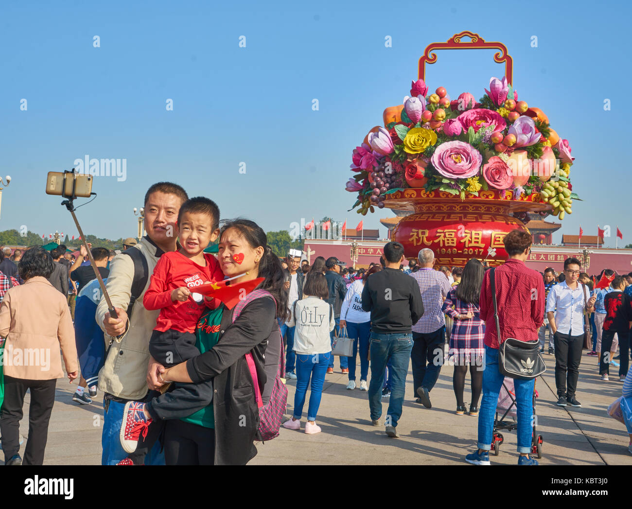 Tiananmen Square, Beijing, China. 1st October, 2017. a chinese family taking photos in front of the big flower basket installation on Tiananmen Square, Beijing, China, in the China National Day of 2017 Credit: Yi Liao/Alamy Live News Stock Photo