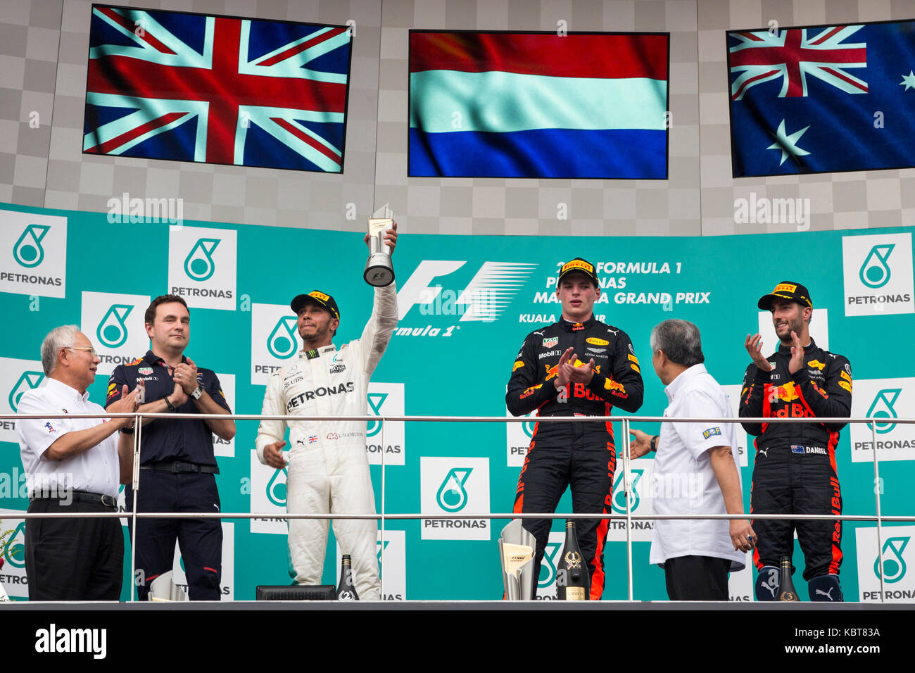 Lewis Hamilton (L) from Mercedes, Max Verstappen (C) and Daniel Ricciardo (R) from RBR TAG Heuer celebrate their victory in the F1 Grand Prix at the Sepang F1 circuit. Verstappen finished the race in the first position, Hamilton came second and Ricciardo won the 3rd place. On October 01, 2017 in Kuala Lumpur, Malaysia. Stock Photo