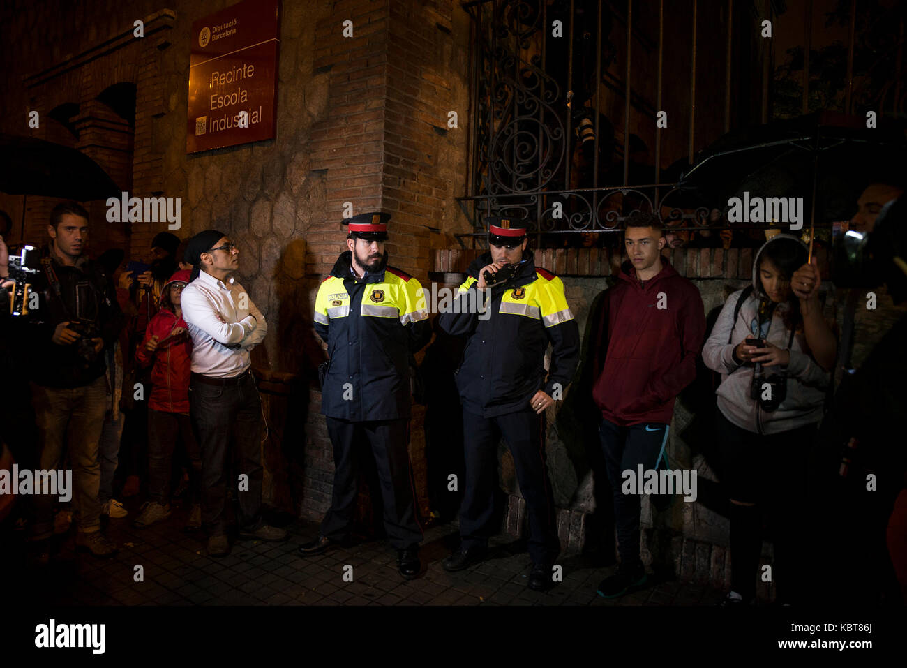 Catalan police of the 'Mossos d·Esquadra' standing among people who have gathered outside Escola de Treball school in Barcelona, Spain, in the early houes of 1 October 2017. Hundreds of people have assembled around polling stations in Catalonia to protect the buildings for the independence referendum set for this day. Photo: Nicolas Carvalho Ochoa/dpa Stock Photo