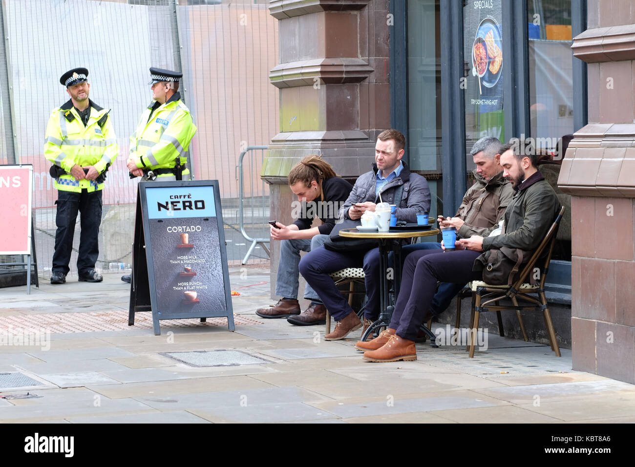 Central Manchester UK, Sunday 1st October 2017 - Conservative Party delegates enjoy a coffee break just outside the central Conservative Party Conference zone in the city centre on the opening day of the Conservative Party Conference. Steven May / Alamy Live News Stock Photo