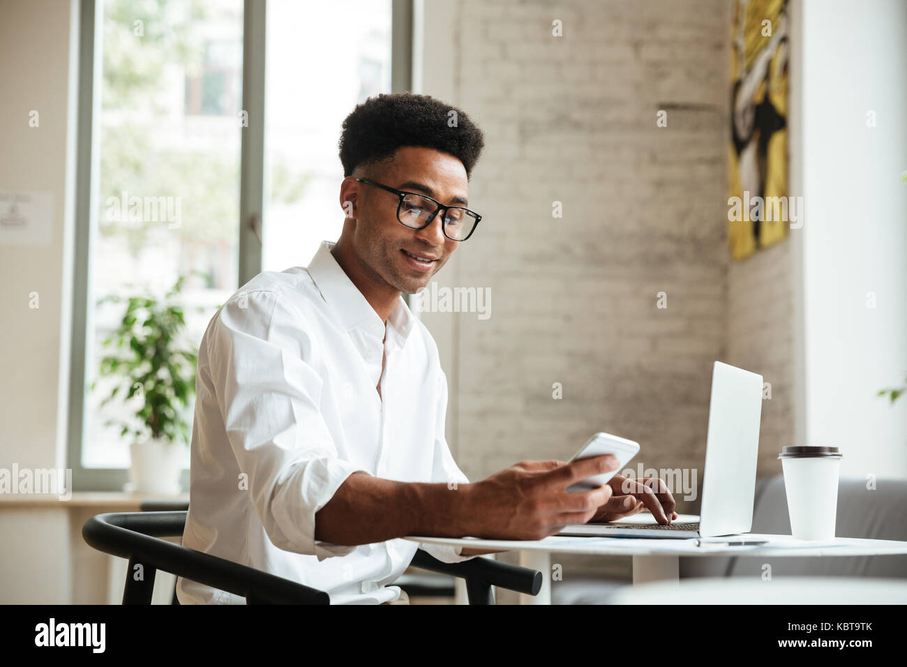 Photo of handsome young african man sitting coworking with laptop ...
