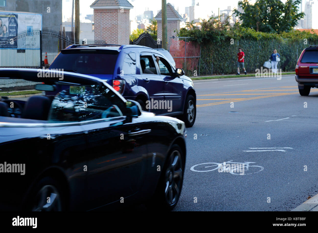 Cars speeding on a road shared with bicyclists as indicated with a sharrows symbol Stock Photo