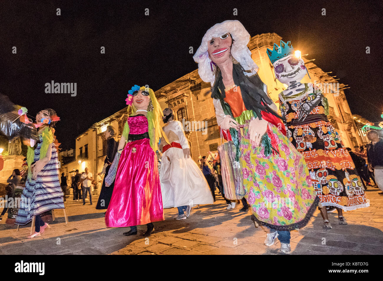Giant papermache puppets called mojigangas dance past the Parroquia