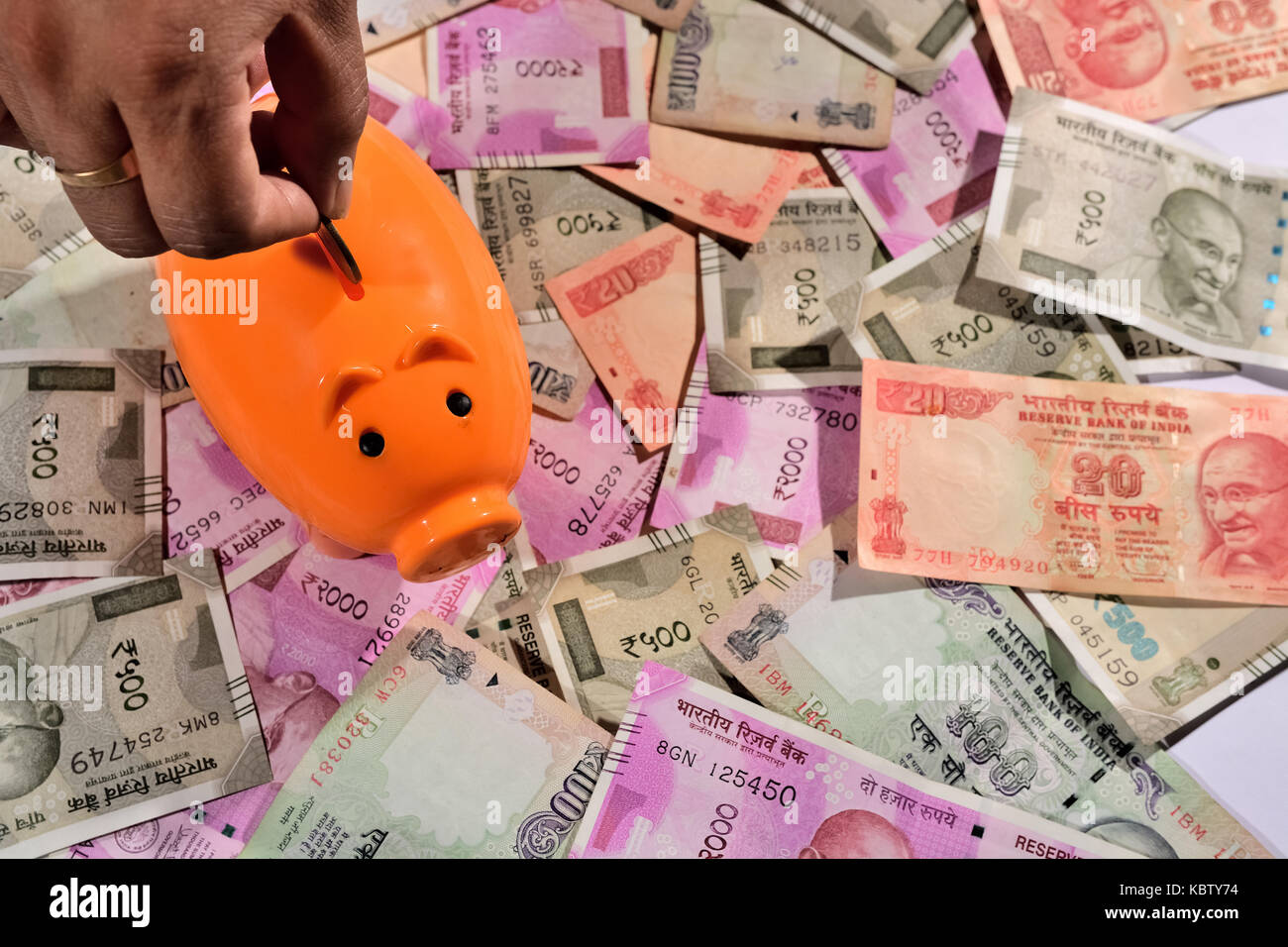 Saving Indian currency in Piggy bank Stock Photo - Alamy