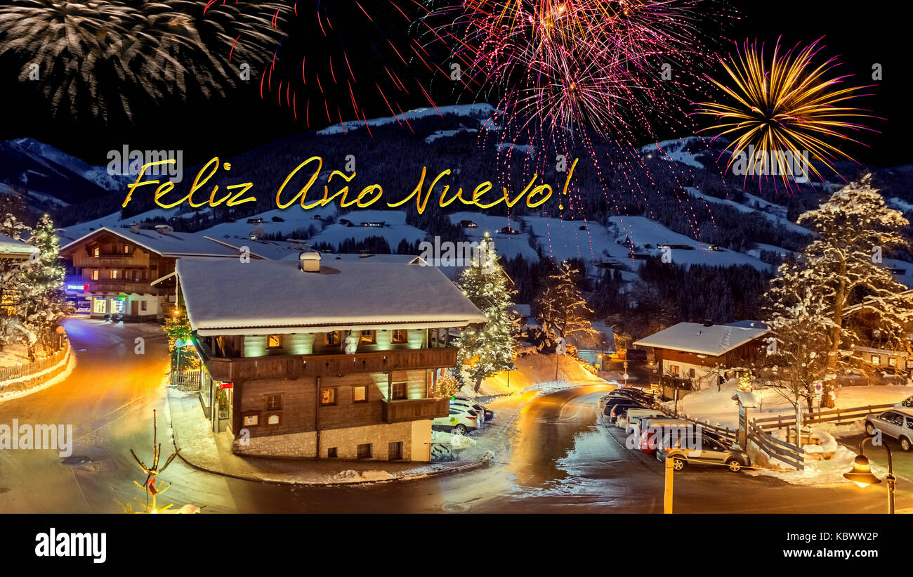 new year's eve card with alpine village in snow, fireworks, text 'Feliz Ano Nuevo!' Stock Photo