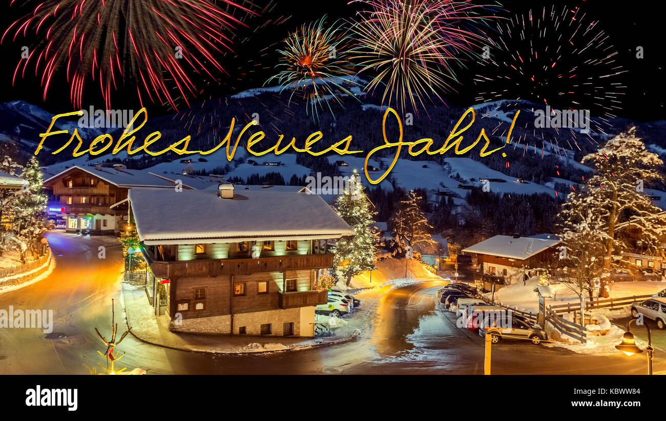 new year's eve card with alpine village in snow, fireworks, german text 'Frohes Neues Jahr!' Stock Photo