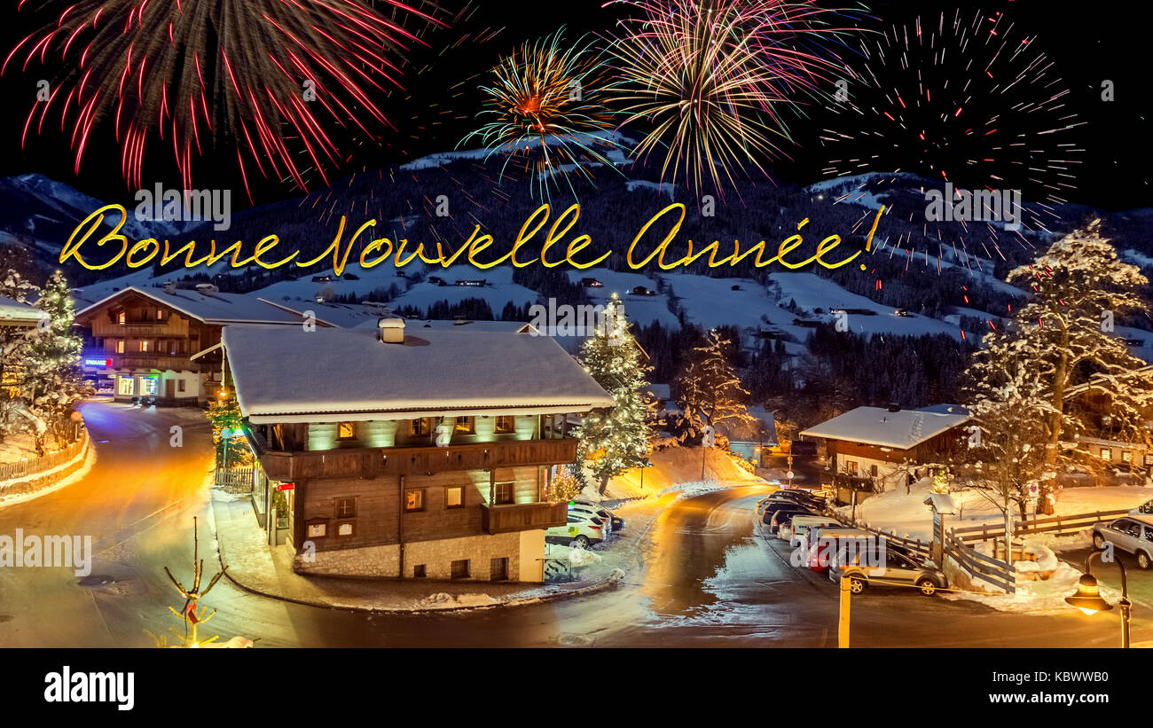 new year's eve card with alpine village in snow, fireworks, french text  "Bonne Nouvelle Annee! Stock Photo - Alamy
