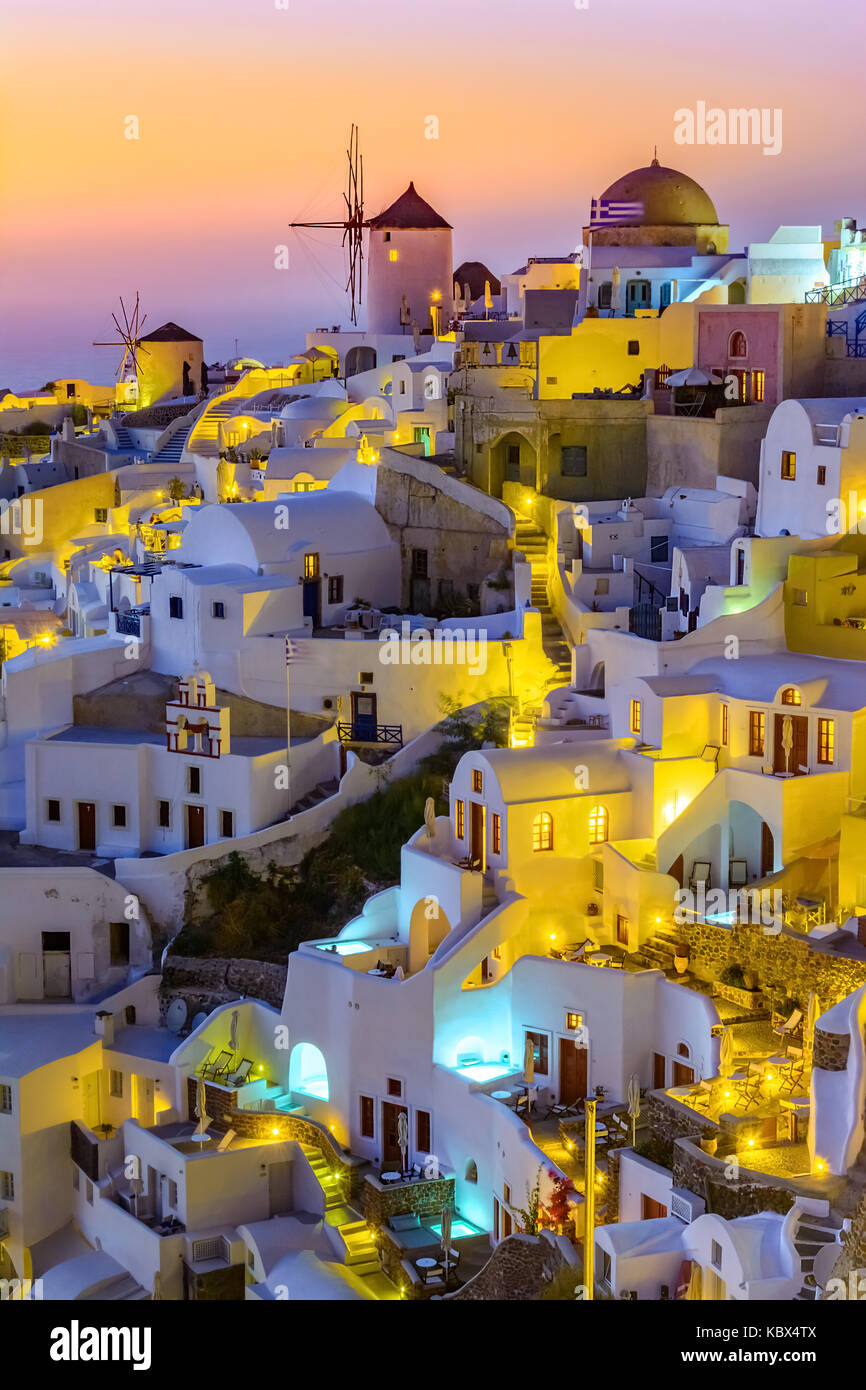 Aerial view of  Oia town, Santorini island, Greece at sunset. Traditional and famous white houses and churches  with blue domes over the Caldera, Aege Stock Photo