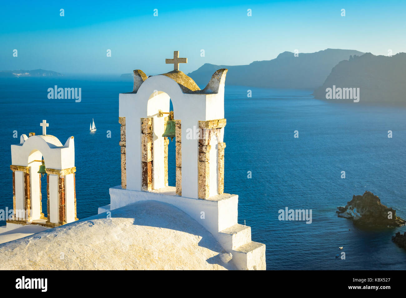 Church bells on a Greek Orthodox Church overlooking the Aegean Sea in the town of Oia on the island of Santorini in the Cyclades off the coast of main Stock Photo