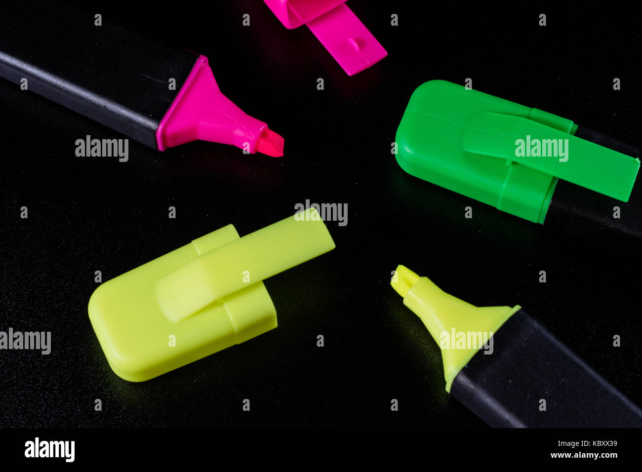 Office Highlighter on a black background. Office Mazak to draw are lying on a black countertop. Black background. Stock Photo