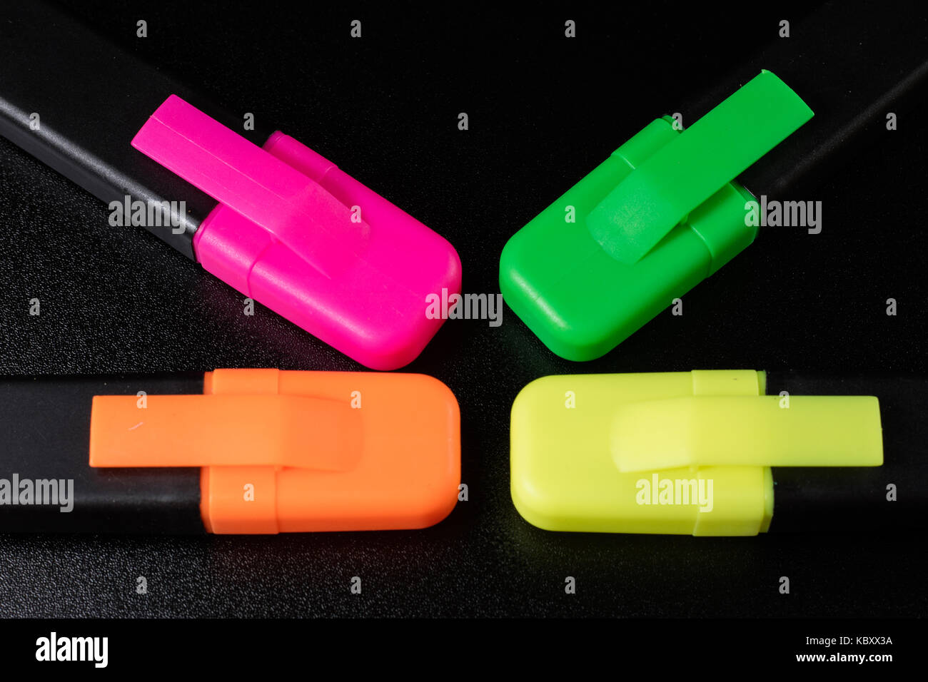 Office Highlighter on a black background. Office Mazak to draw are lying on a black countertop. Black background. Stock Photo