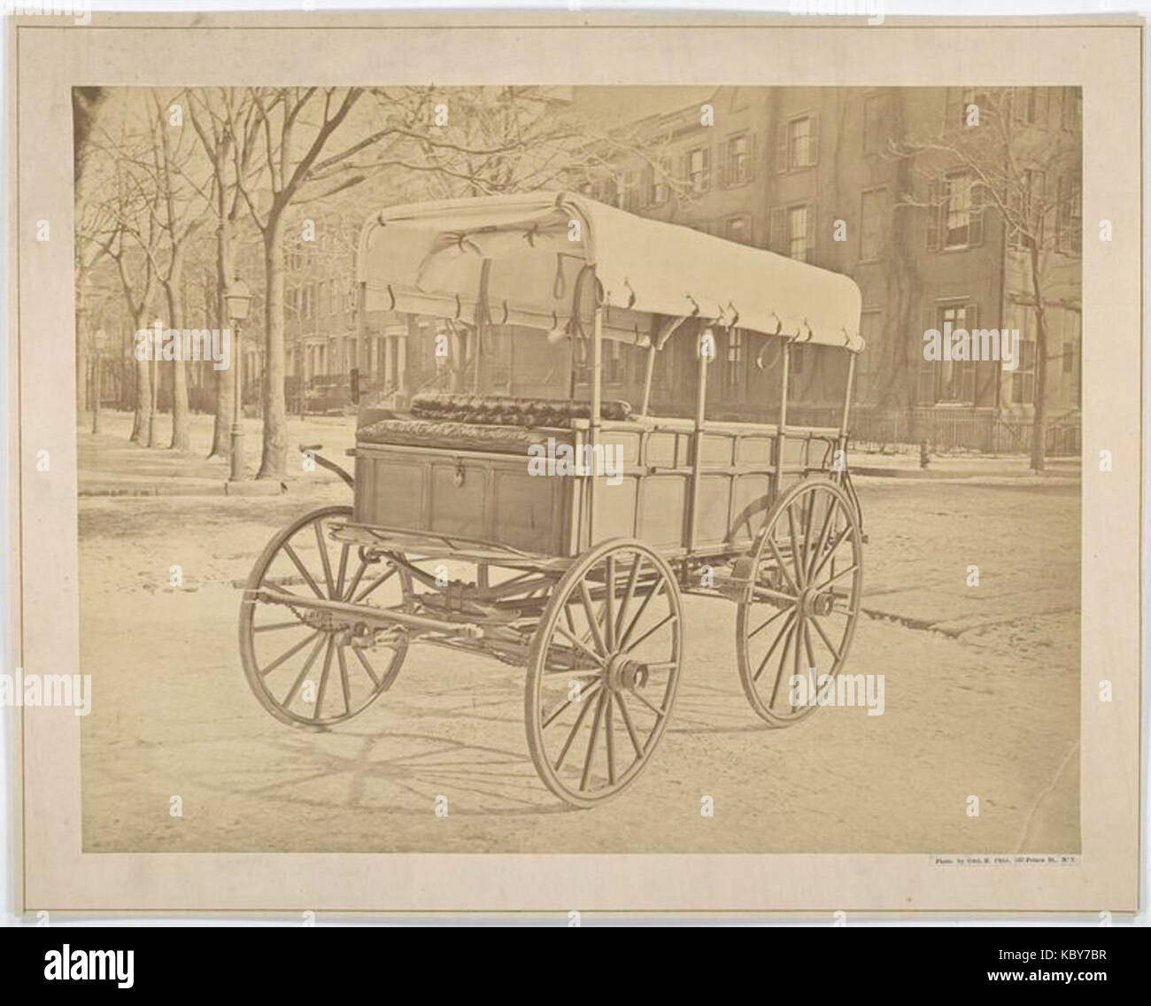 This photograph shows a Howard ambulance from the early 20th century, captured from both the front and side, on an urban city street. Stock Photo