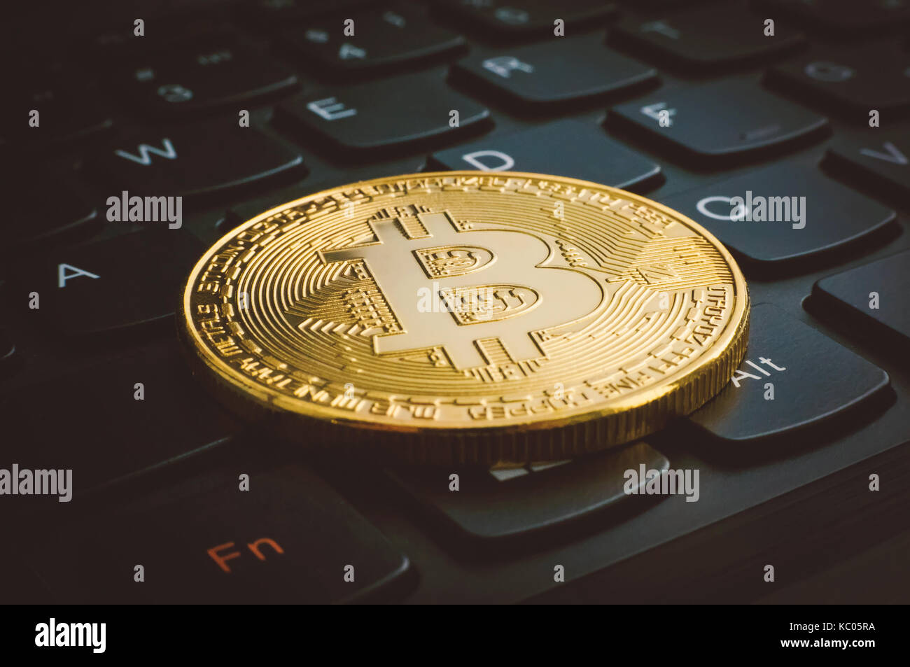 Golden bitcoins on a black computer keyboard. The electronic coin ...