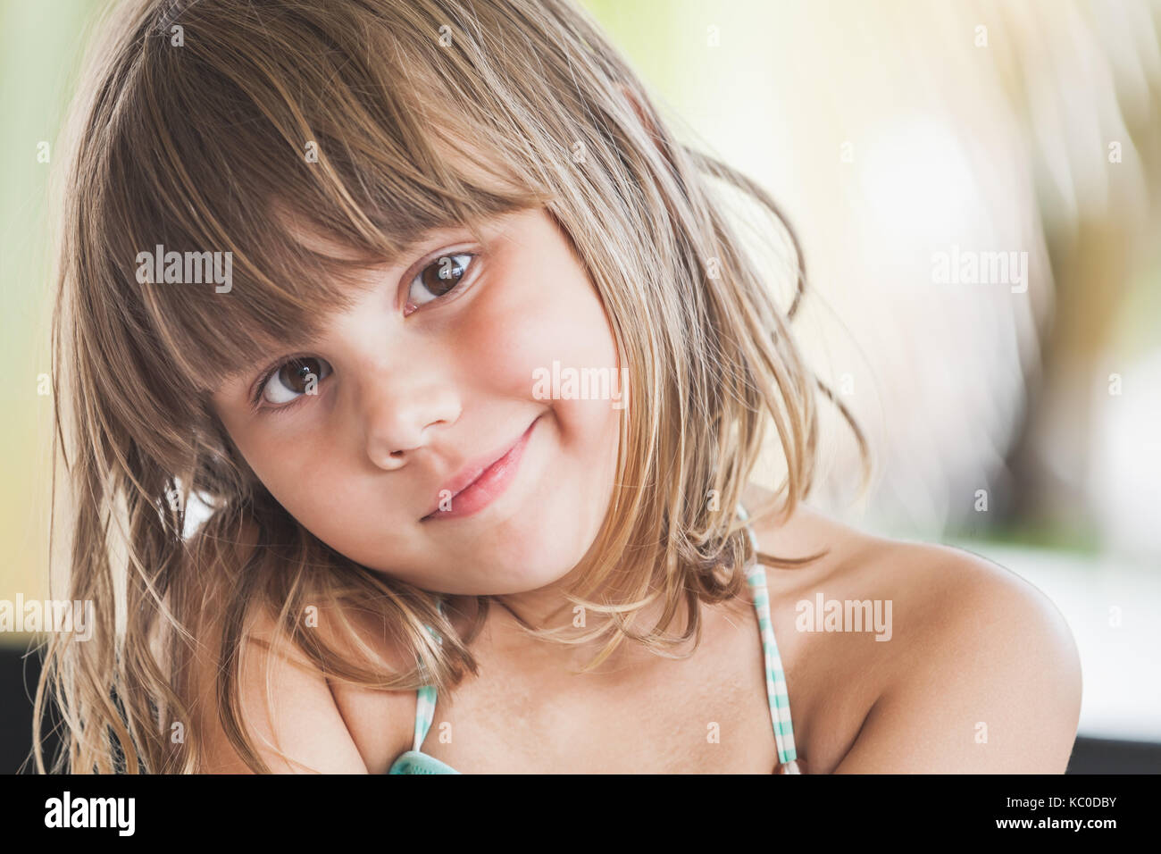 Slightly smiling Caucasian little girl, close-up outdoor face portrait Stock Photo