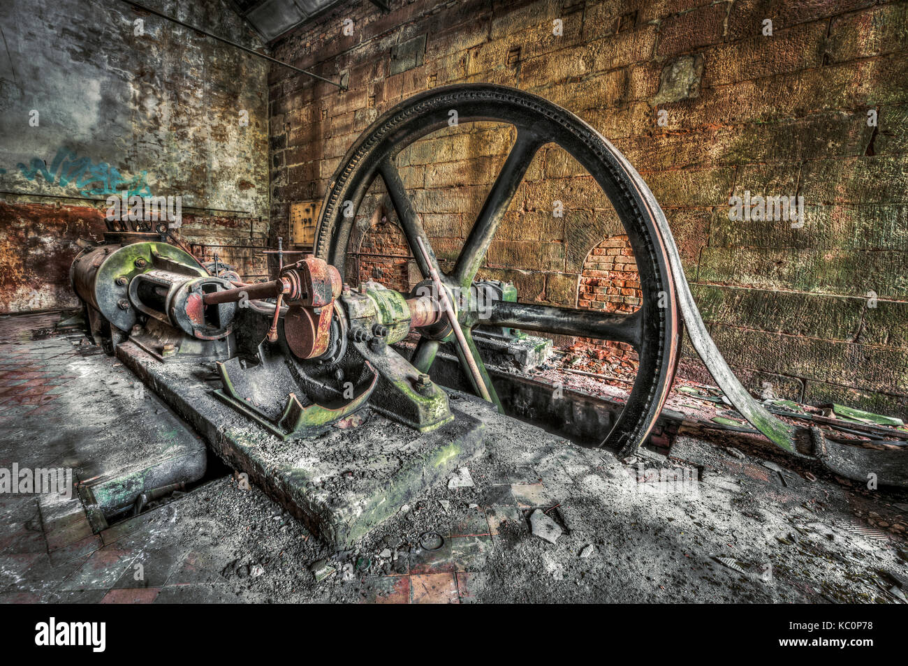 Antique belt driven steam engine in an abandoned factory Stock Photo