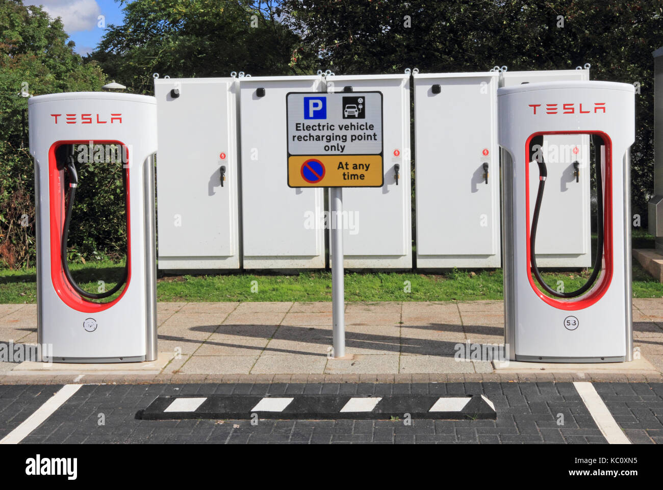 Tesla electric car charging points with control boxes behind, Hopwood Motorway Services, Alvechurch, Birmingham Stock Photo