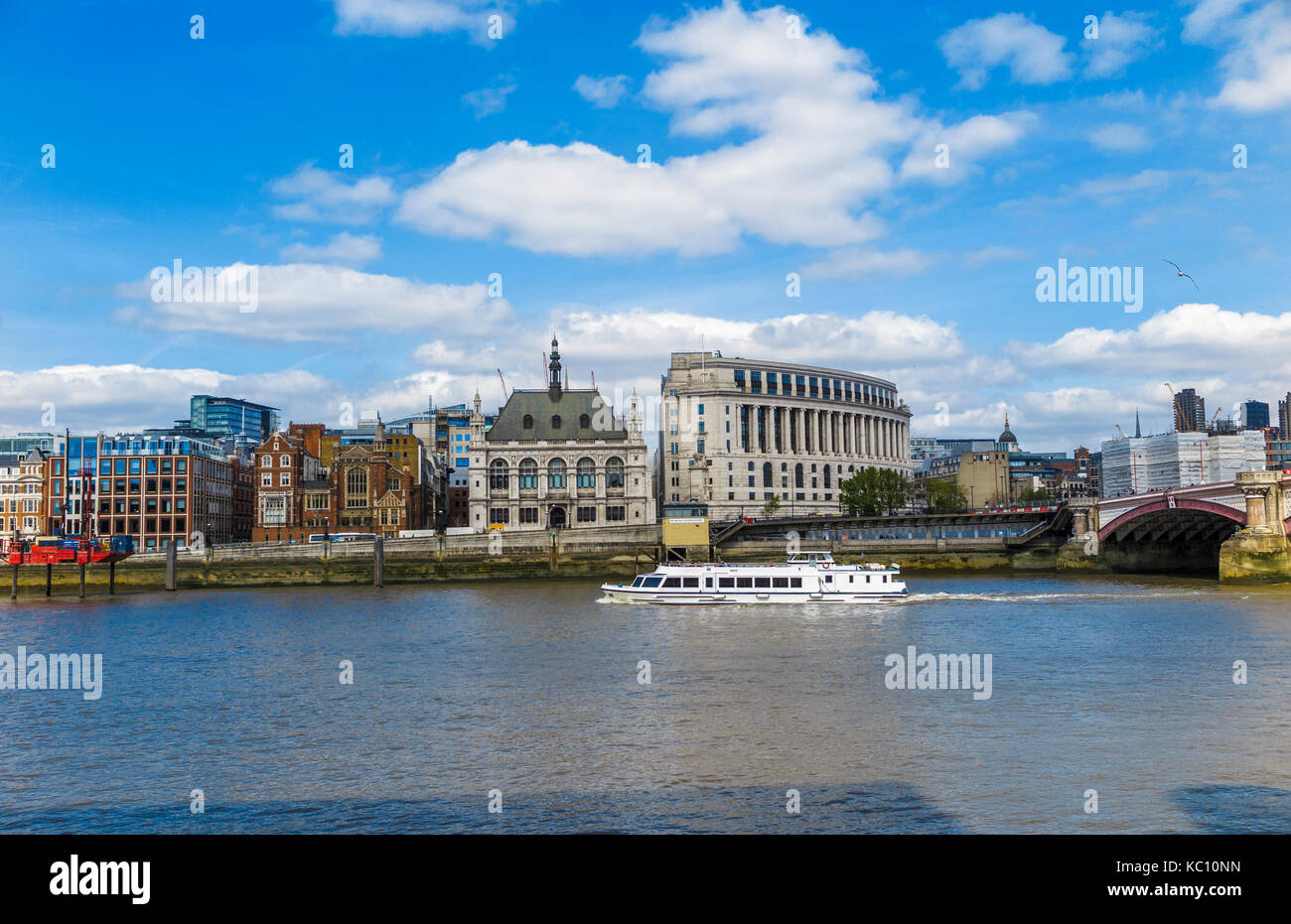 White river cruise tourist sightseeing boat sails along the River Thames by Unilever House and 60 Victoria Embankment, London EC4 on a sunny day Stock Photo