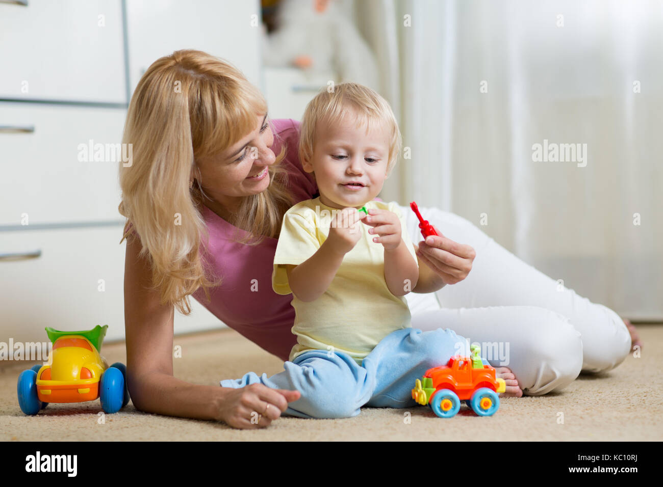 cute mother and kid boy play together indoors at home Stock Photo