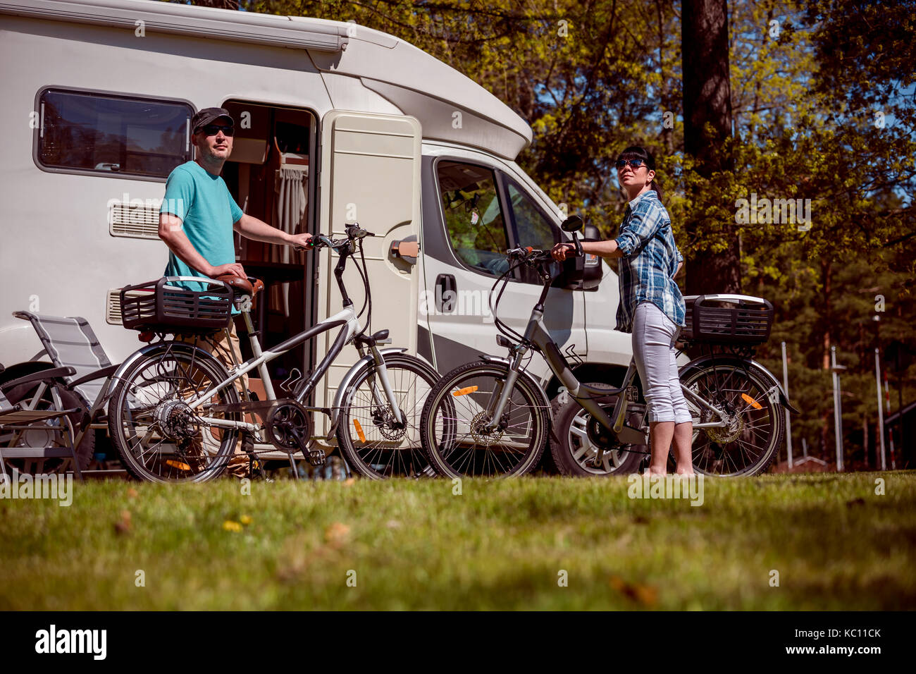 Woman with a man on electric bike resting at the campsite. Family vacation travel, holiday trip